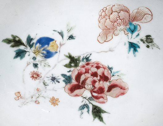 图为清中期粉彩花卉纹剃须盘细节图，盘心主题纹饰为花卉图。（来源：广州十三行博物馆）